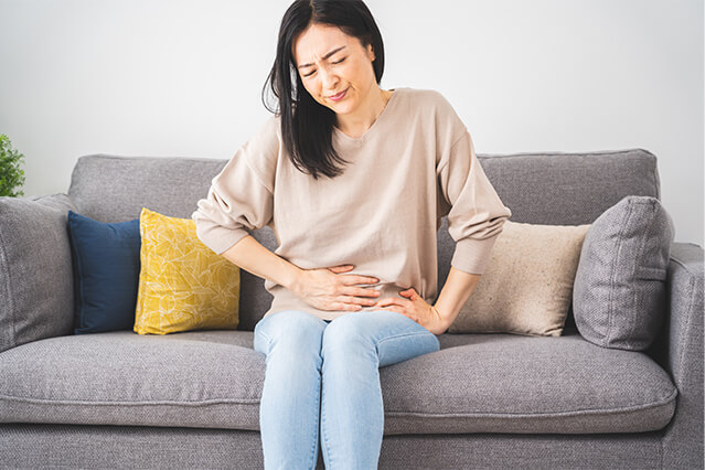 お腹の不調を感じている女性