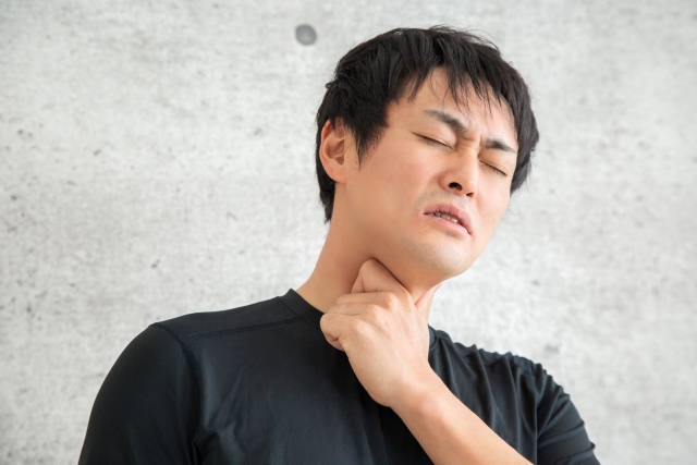 咽を抑える男性