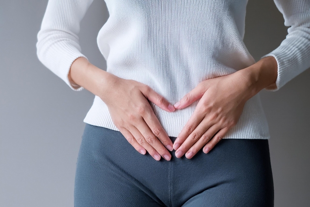 下っ腹をおさえる女性